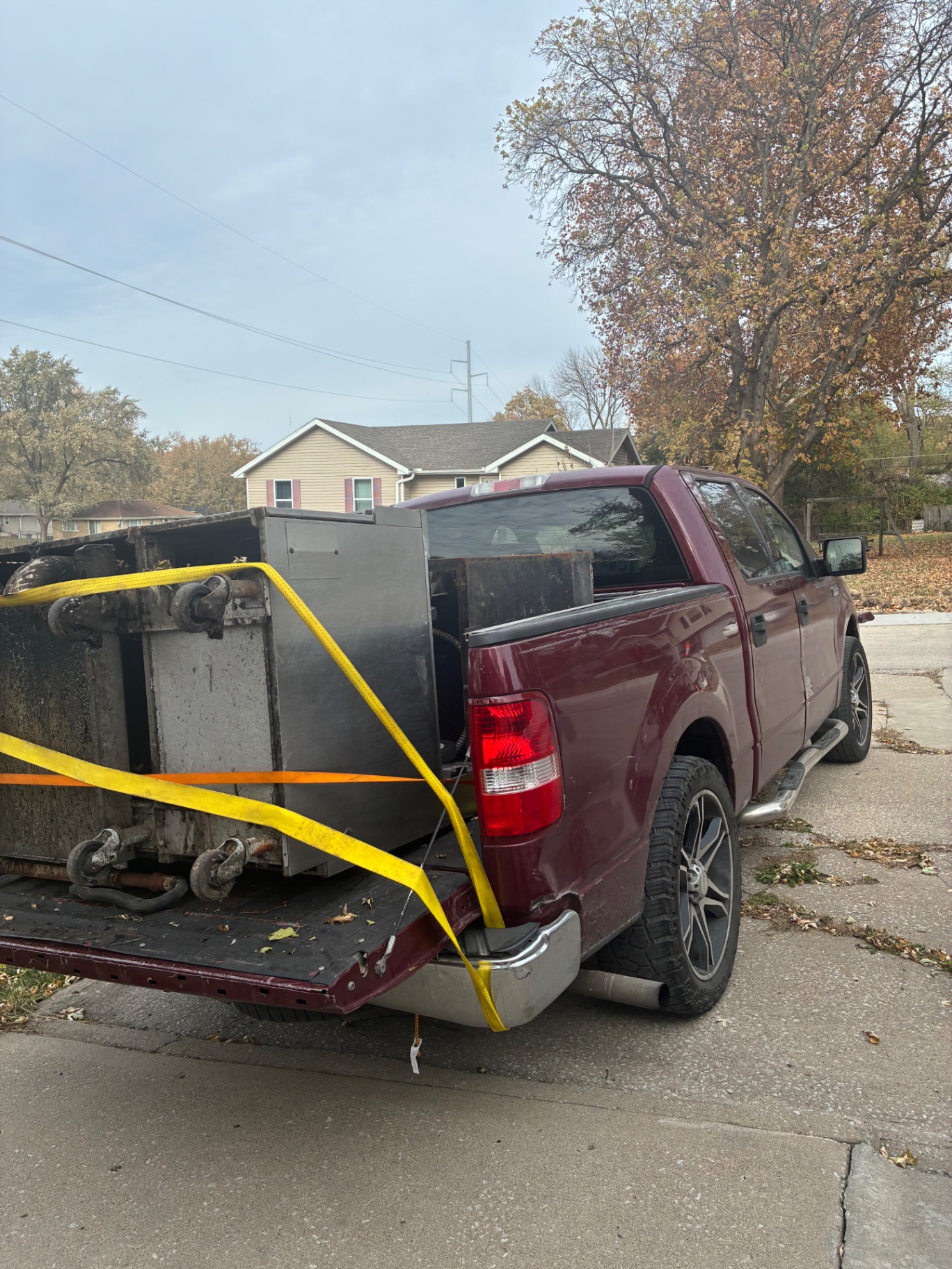 SBH Moving Helper truck hauling a loaded junk container in Kansas City